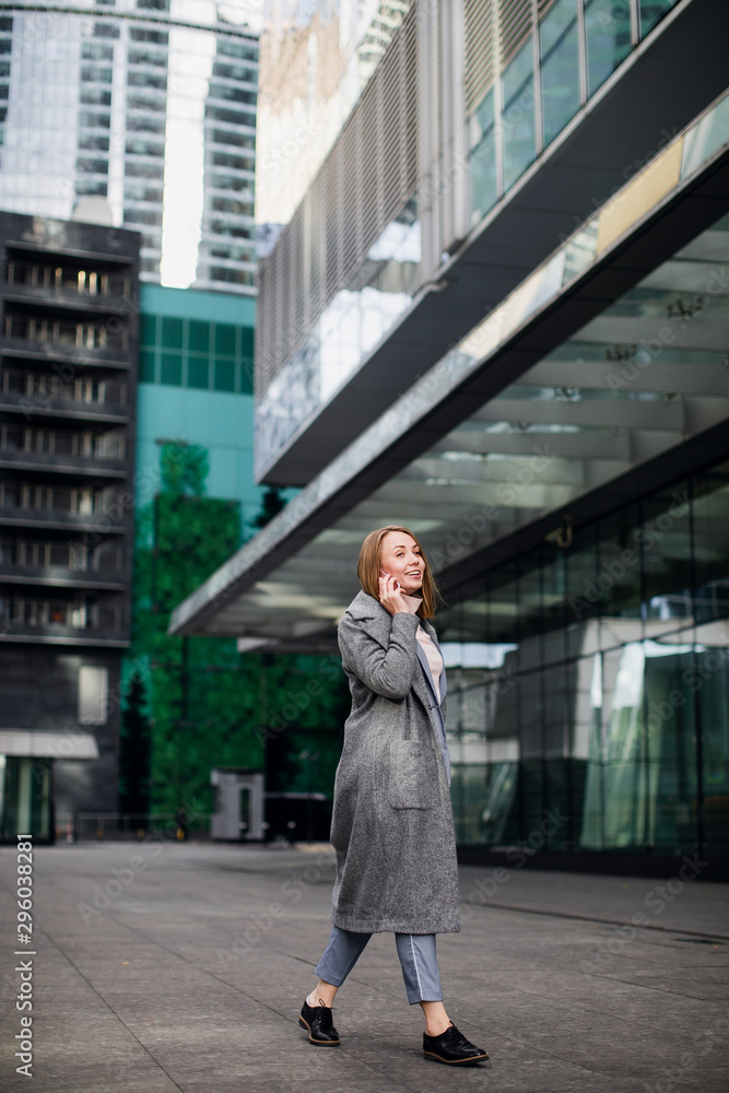 business woman talking on the phone in the background of an office building business woman talking on the phone in the background of an office building