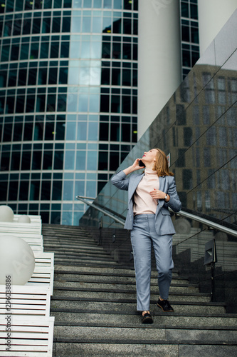business woman talking on the phone in the background of an office building © kalinichenkod