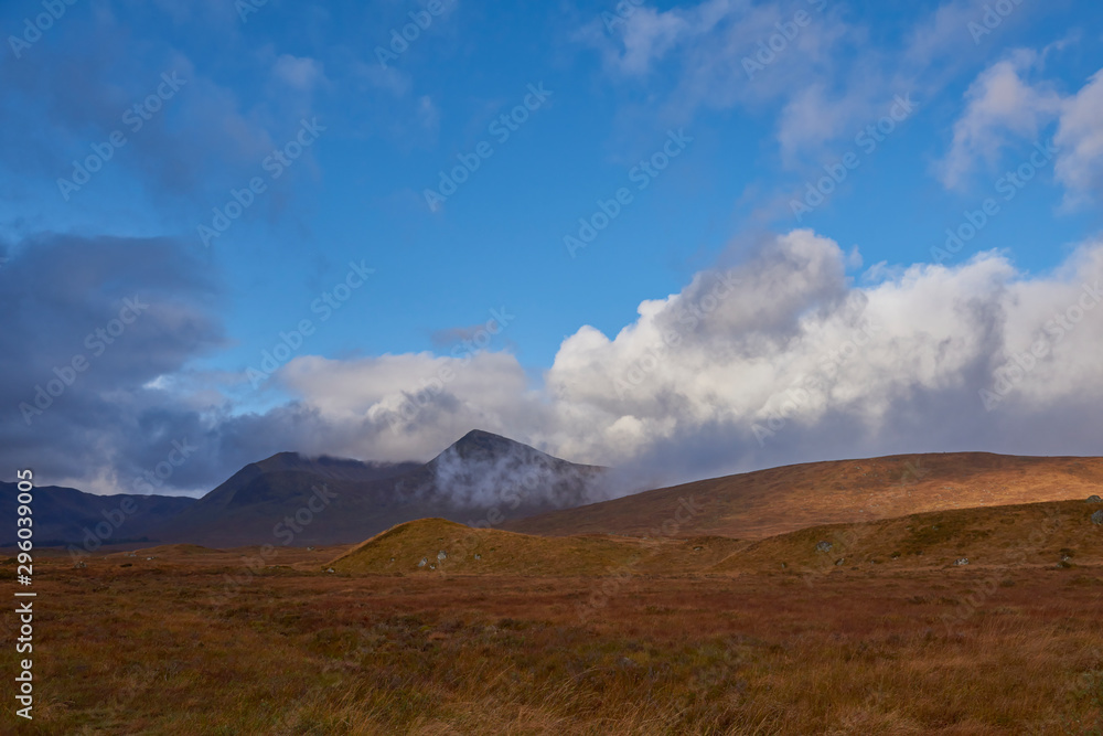 Sunlight breaking through the low cloud on to the rolling hills of Rannoch Moor, a vast boggy moorland close to Glencoe in Perth and Kinross.