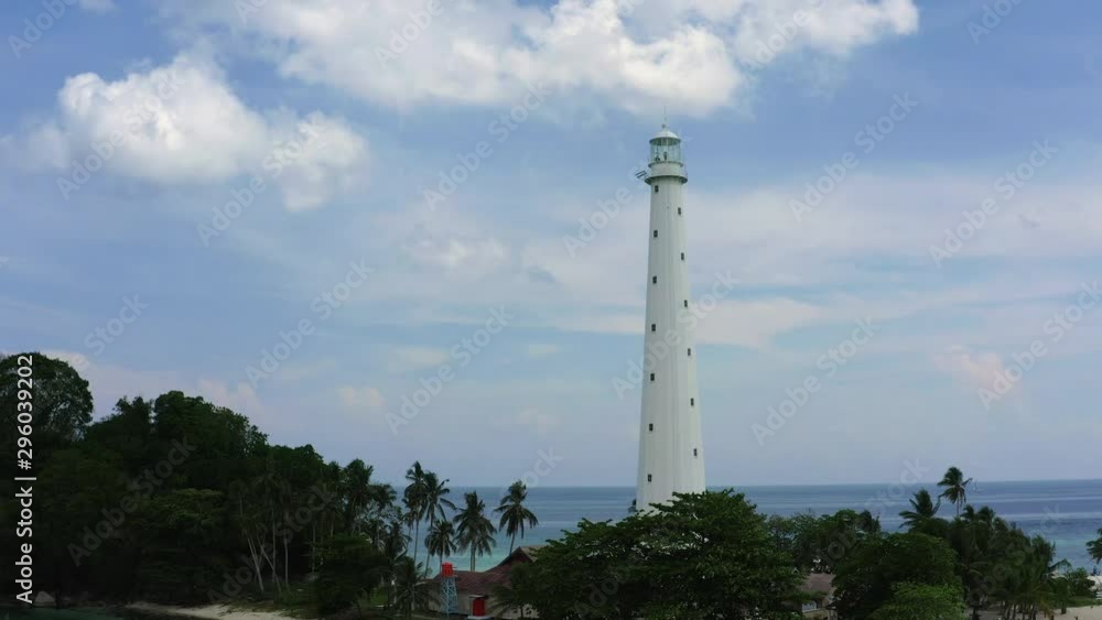 Aerial View of Light House at Lengkuas Island of Belitung Indonesia. Dramatic Tropical island with White Sandy beach and Trees. fly by and close up drone shot Aerial View of Light House at Lengkuas Island of Belitung Indonesia. Dramatic Tropical island with White Sandy beach and Trees. fly by and close up drone shot
