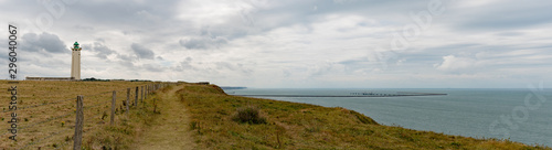 panorama view of ocean and coast with green fields and jagged cliffs