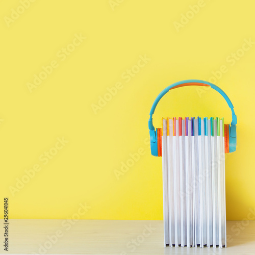 Colorful Headphones and books on color background. Concept of audiobook.