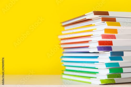 Bild auf Leinwand Stack of colorful books on color background.