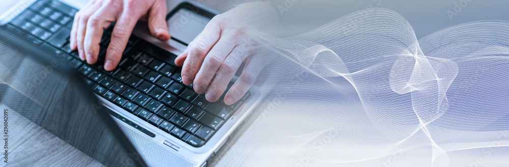 Male hands using a laptop; panoramic banner Male hands using a laptop; panoramic banner