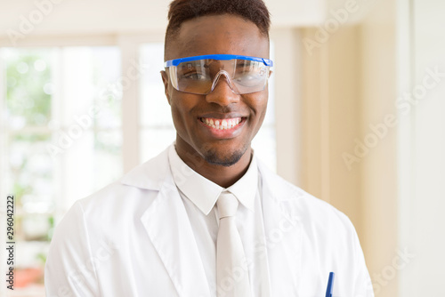 African young scientist man wearing safety glasses working with chemical equipment smiling confident © Krakenimages.com