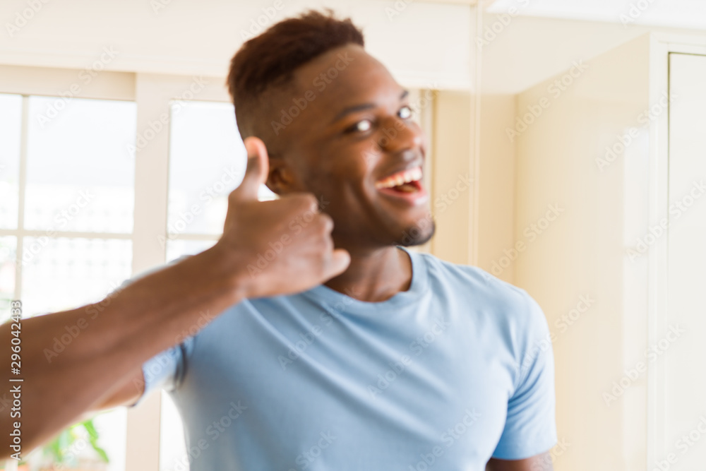 Handsome african young man doing thumbs up gesture, great symbol for succes smiling excited Handsome african young man doing thumbs up gesture, great symbol for succes smiling excited