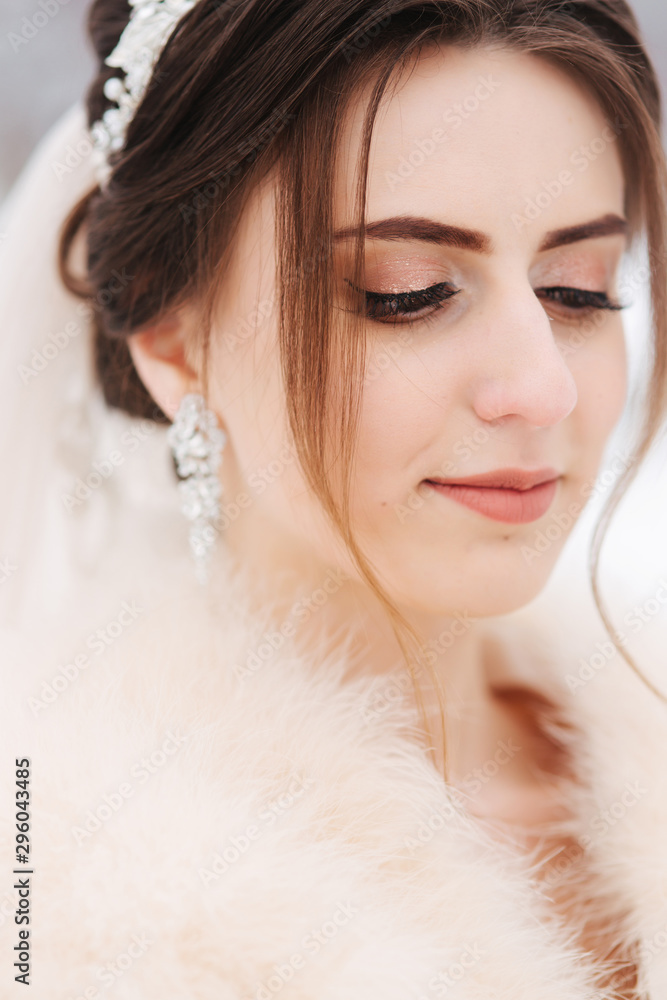 Beautiful bride in winter park. Young bride with wedding bouquet. Woman smile