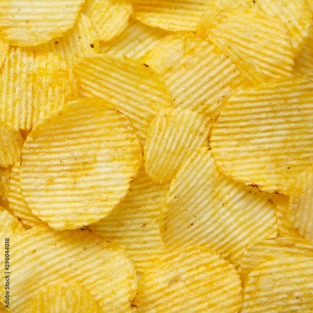 Salted wavy potato chips, overhead view. Top view, from above, flat lay. Closeup. Salted wavy potato chips, overhead view. Top view, from above, flat lay. Closeup.