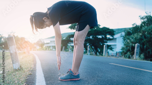 attractive sportsmen girl stretching in the park before running at the sunset focus on shoes.Exercise concept. sport lifestyle.