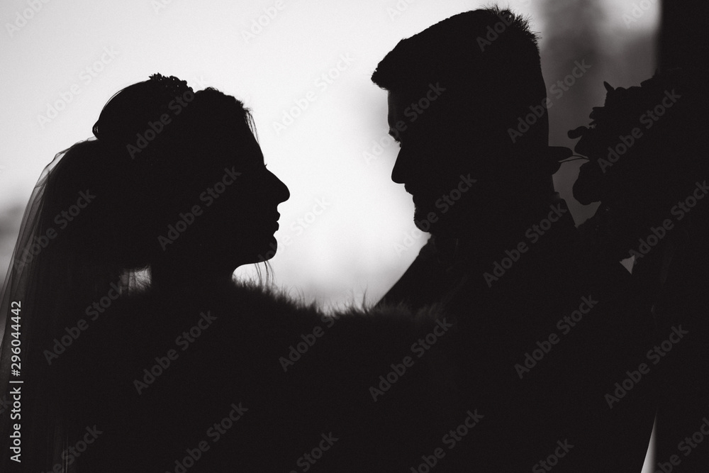 Silhouette of groom and bride. Black and white photo
