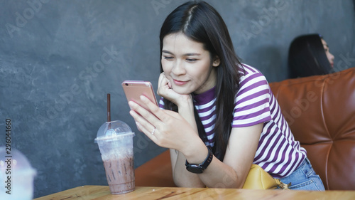 Young woman Smiling face vdo calling with cell smartphone while sitting  in coffee shop during free time