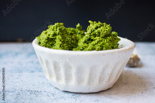 Green fresh pesto dip paste with spinach and nuts. Vegan or vegetarian food.