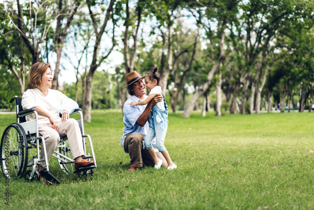 Portrait of happy grandfather with grandmother and little cute girl enjoy relax in summer park.Young girl with their laughing grandparents smiling together.Family and togetherness Portrait of happy grandfather with grandmother and little cute girl enjoy relax in summer park.Young girl with their laughing grandparents smiling together.Family and togetherness