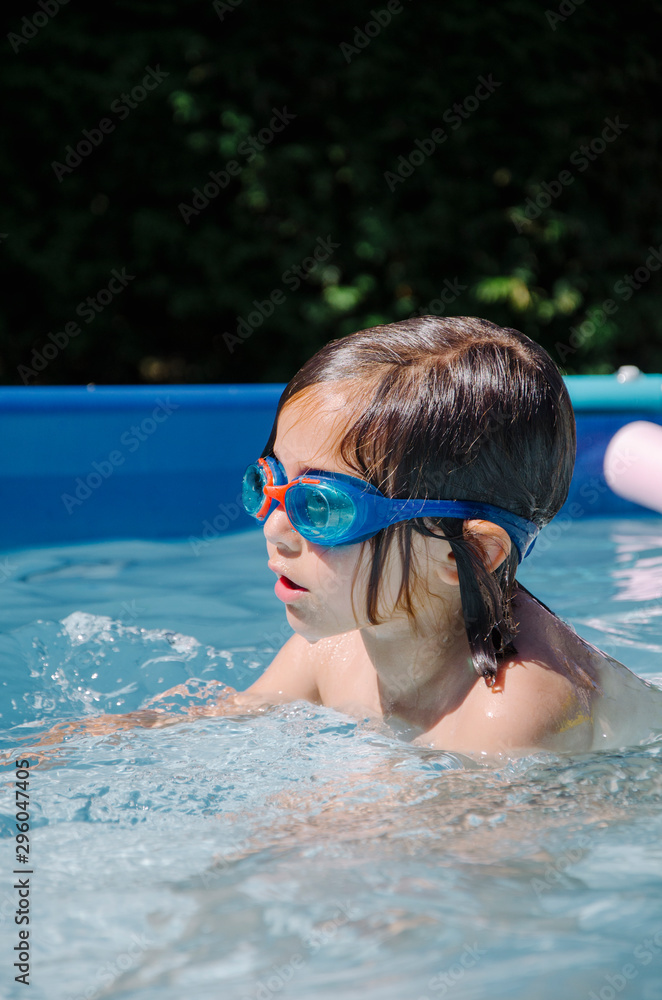 A girl caucasian enjoys playing happy in the home pool 