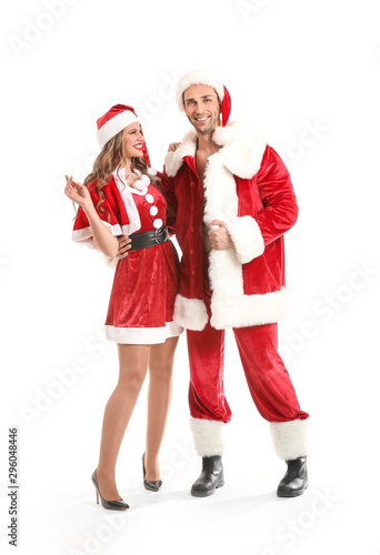 Young couple dressed as Santa Claus on white background