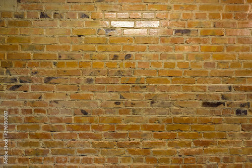 Old yellow brick wall. Faded yellow color, a bit dirty. Interior