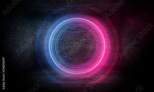 Neon circle on the background of a dark old brick wall, street, wet asphalt. Blue and pink neon, smoke, smog. Night view of the street with neon. Abstract neon dark background.