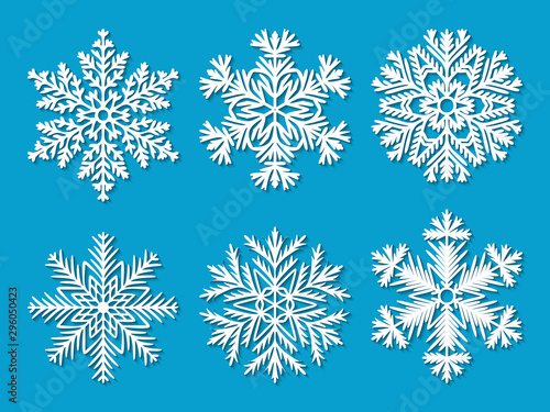 Set of six white paper cut out highly detailed snowflakes on blue background. Vector illustration