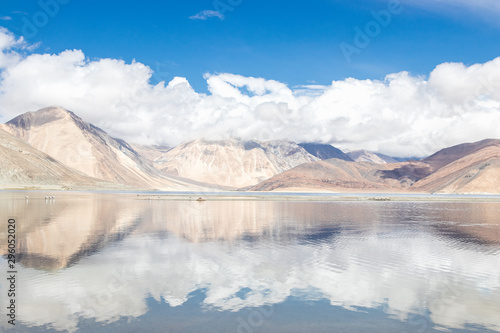 Reflections of high mountain with white cloud and blue sky on the Pagong lake, Leh Ladakh, India.