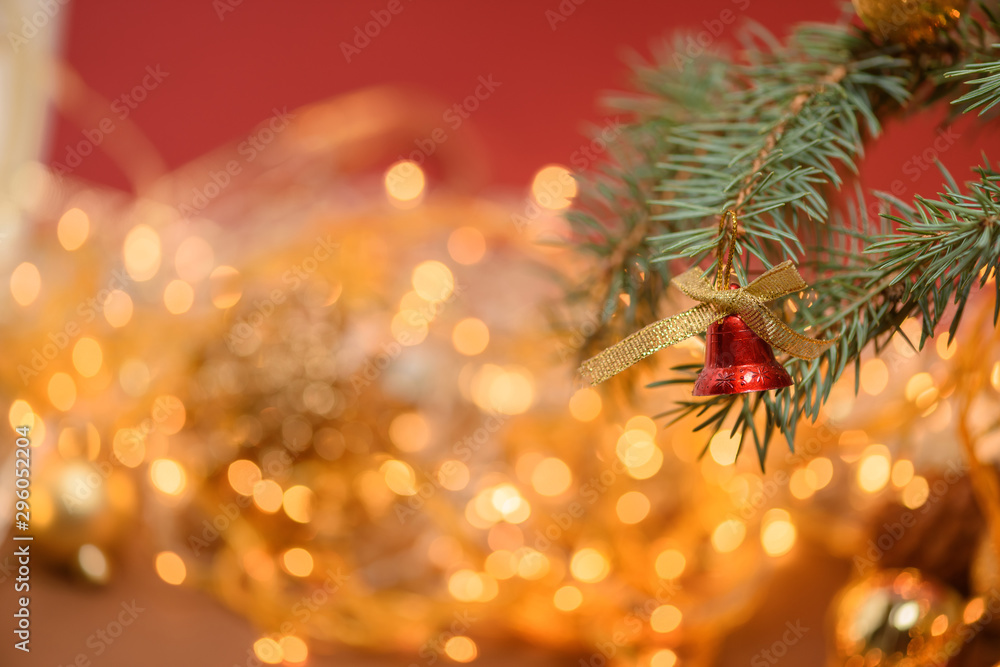 Christmas Golden toy bell on a spruce branch on the background of a Christmas garland . template for postcards . space for text