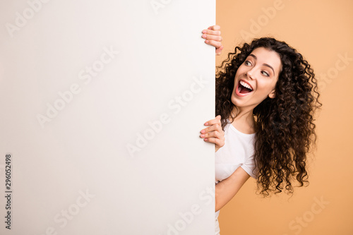 Photo of amazing lady holding big white placard presenting novelty information not believe sale prices wear white casual clothes isolated beige pastel color background