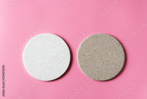 Round coasters made of artificial stone tabletop on a pink background. Food stand.