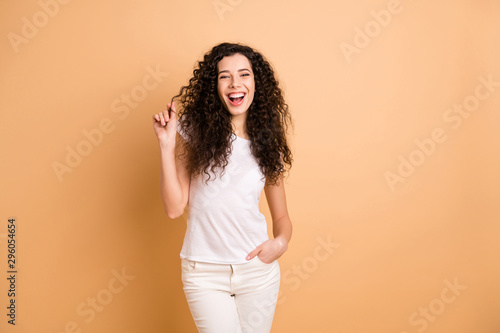 Photo of pretty funny lady showing perfect condition wavy curls after visiting amazing salon stylist wear white casual clothes isolated beige pastel color background