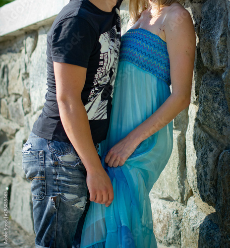 Lovers cuddle near a stone wall