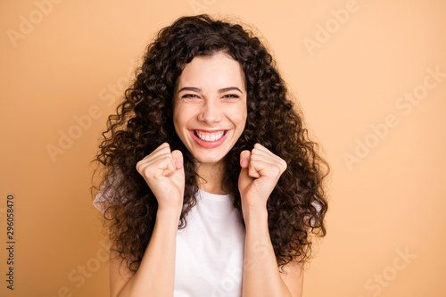 Photo of amazing lady listening great advertising sale shopping triumphing raising fists wear white casual clothes isolated beige pastel color background