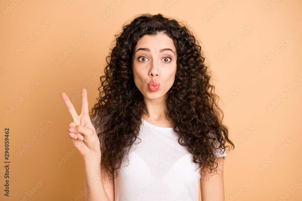 Hi there. Closeup photo of amazing lady showing v-sign symbol sending air kisses handsome guy wear white casual outfit isolated beige pastel color background Hi there. Closeup photo of amazing lady showing v-sign symbol sending air kisses handsome guy wear white casual outfit isolated beige pastel color background