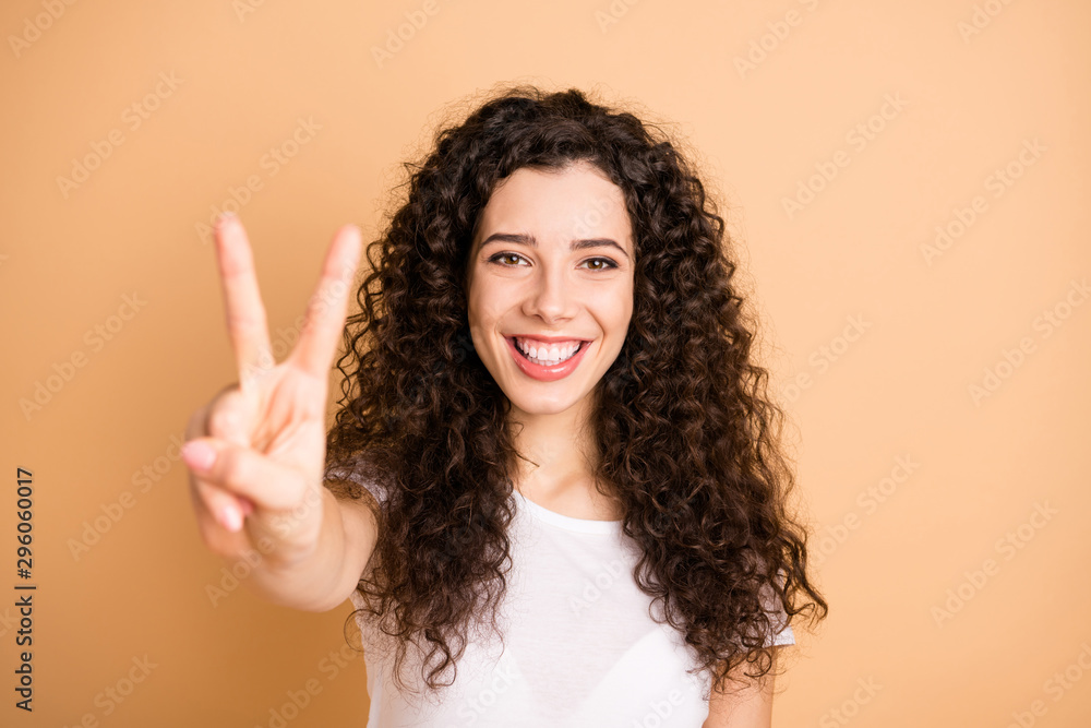 Hello wonderful world. Closeup photo of amazing lady showing v-sign symbol positive mood wear white casual outfit isolated beige pastel color background Hello wonderful world. Closeup photo of amazing lady showing v-sign symbol positive mood wear white casual outfit isolated beige pastel color background