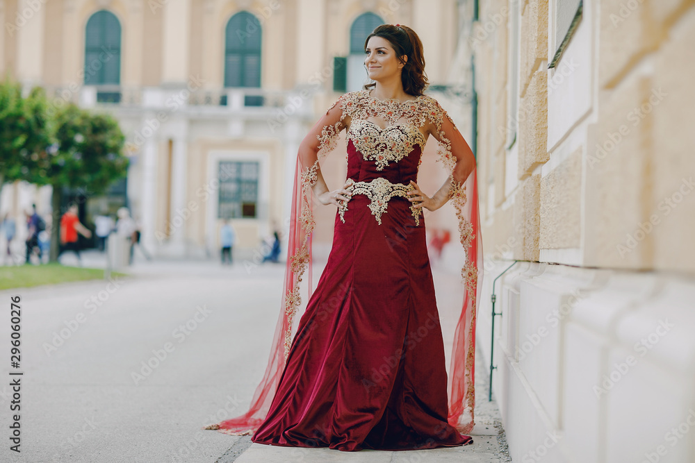 Obraz premium A beautiful Turkish girl in a long red dress walks in the summer old city