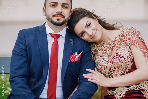 Photography Beautiful woman in a long red dress walks around the city with her husband in a