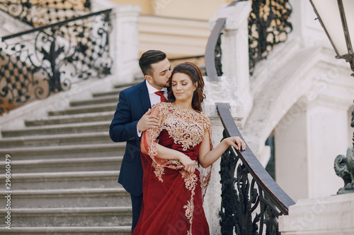 Photography Beautiful woman in a long red dress walks around the city with her husband in a