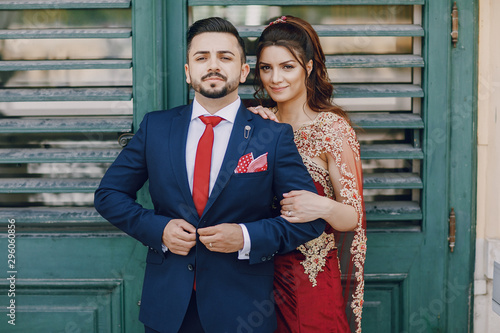 Photography Beautiful woman in a long red dress walks around the city with her husband in a