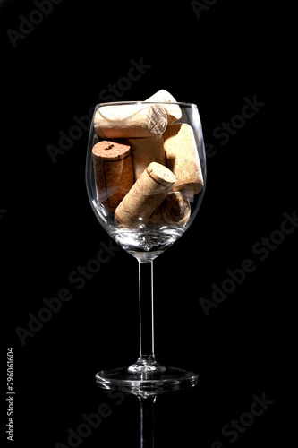 wine glass full of wine cork stoppers isolated on black background  and copy space for your text photo