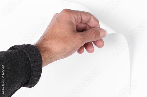Quadro su tela man's hand pull up  a bottom corner of a white paper sheet to uncover a neutral