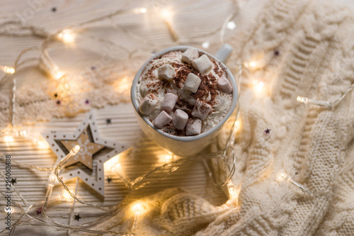 Christmas coffee cup with marshmallows. Still life on white background. New Year's lights and decorations