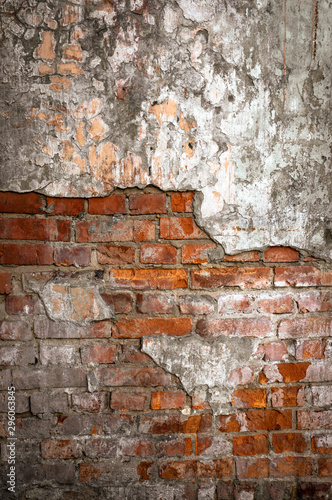 Old brick wall in a background image. Plastered Brickwall With Chipped Stucco Pieces. Red Textured Brick Wall With Damage Surface. Old Grunge Abstract Background