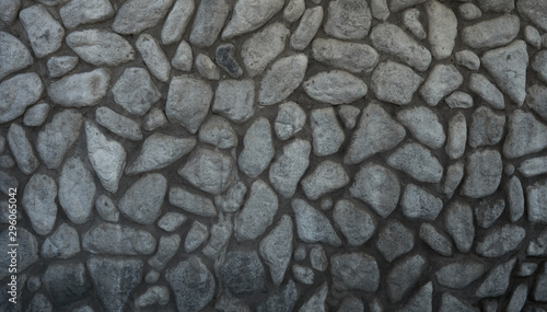 Stone wall background. Unprocessed gray cobblestones
