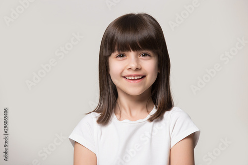 Headshot portrait of happy little girl posing in studio