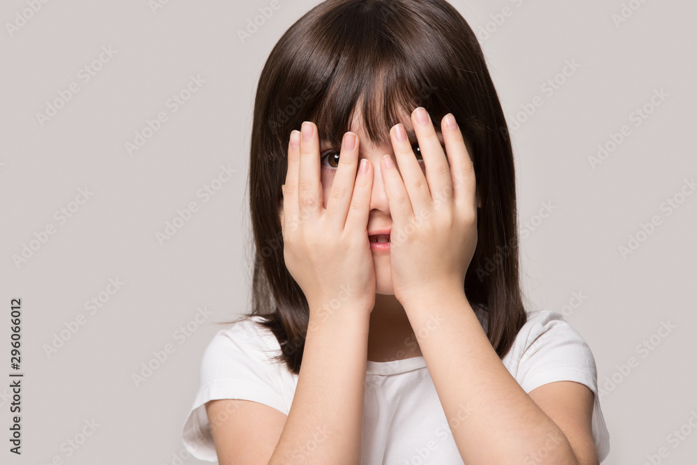 Scared little girl feel interested peep through fingers Scared little girl feel interested peep through fingers