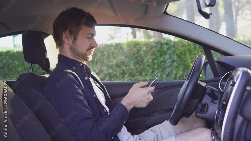 Stylish young man using smart phone in the car. Stylish young man using smart phone in the car.