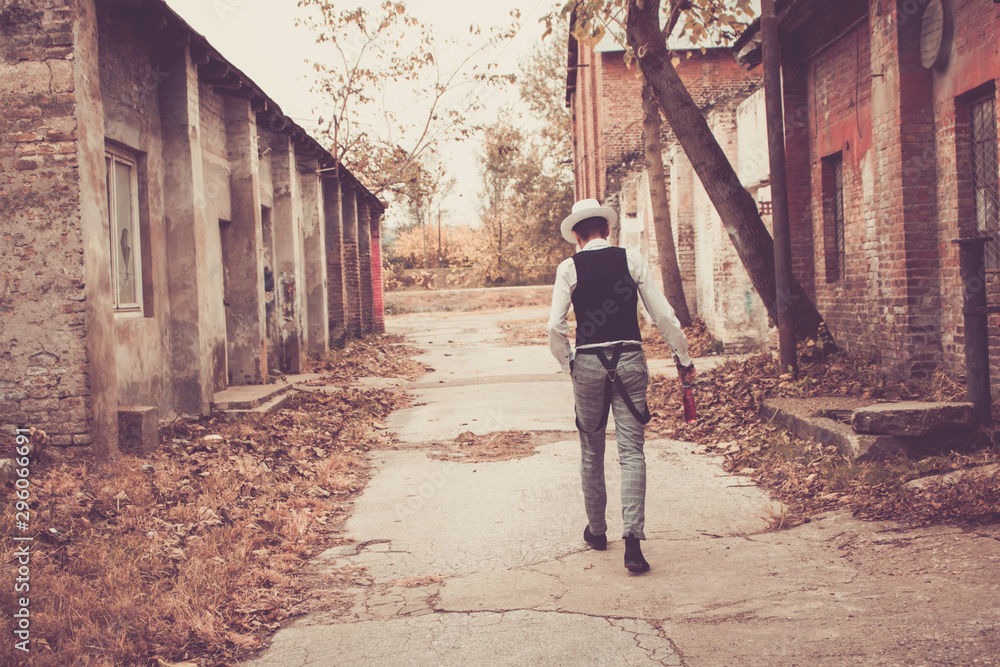 Rear view of fedora styled man walking through the town.