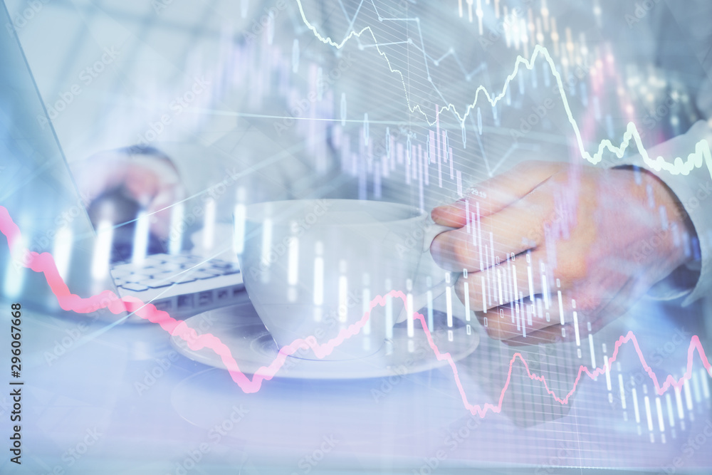 Double exposure of graph with man typing on computer in office on background. Concept of hard work. Double exposure of graph with man typing on computer in office on background. Concept of hard work.