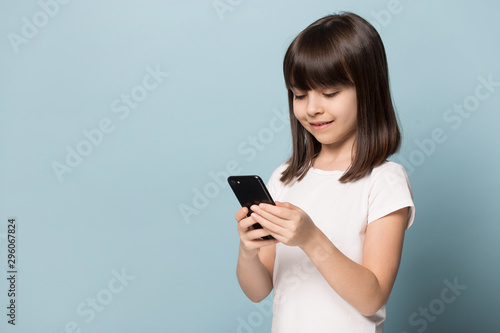 Little girl using modern smartphone watching cartoons