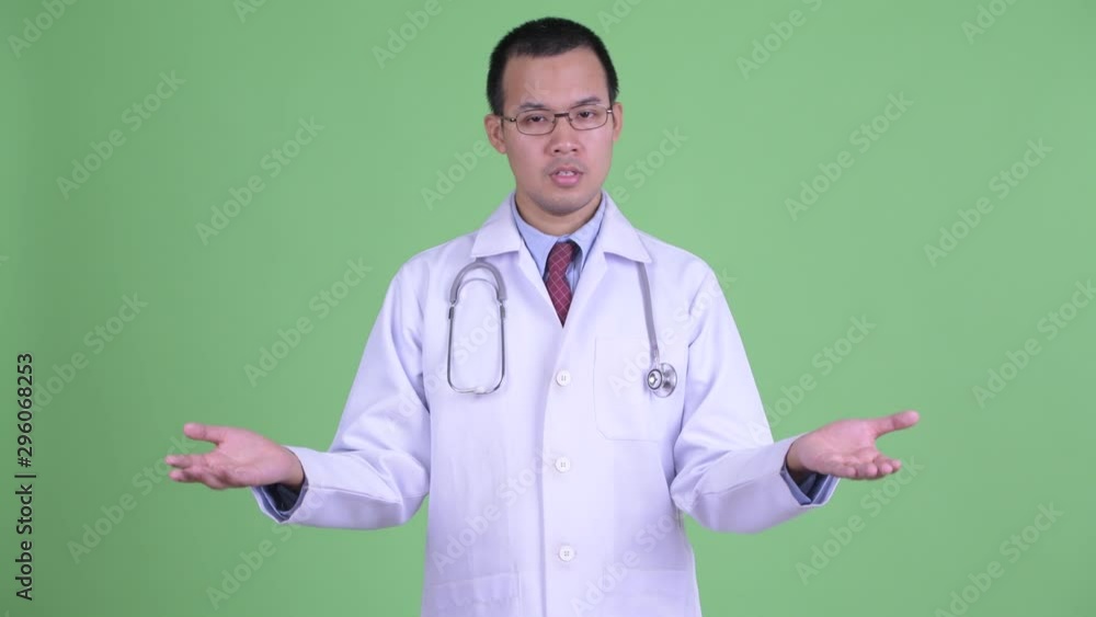 Sad Asian man doctor with eyeglasses shrugging shoulders Sad Asian man doctor with eyeglasses shrugging shoulders
