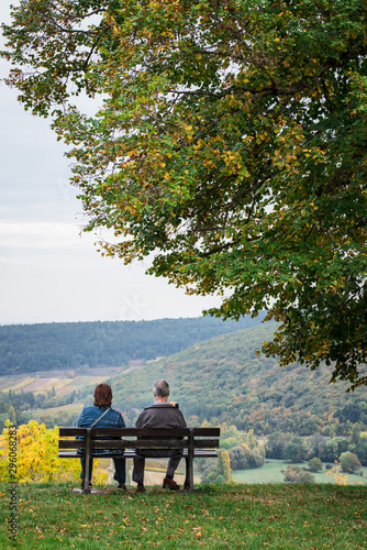 un couple assis sur un banc regarde le paysage
