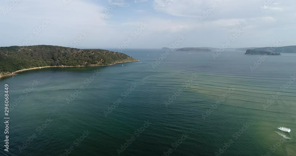 Wide aerial hovering over Broken Bay rugged coast on Australian Central coast around scenic sandstone heads and relaxed towns with sandy beaches. Wide aerial hovering over Broken Bay rugged coast on Australian Central coast around scenic sandstone heads and relaxed towns with sandy beaches.