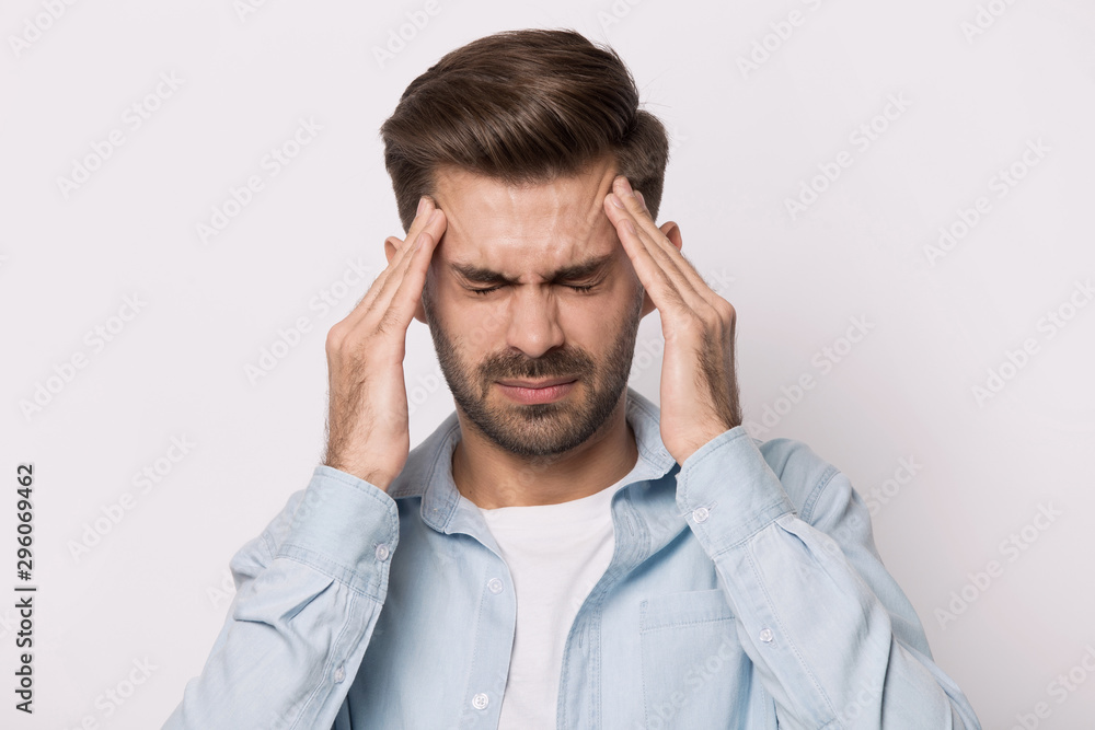 Unwell caucasian man massage temples suffering from severe headache Unwell caucasian man massage temples suffering from severe headache